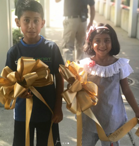 Gigi and brother with ribbons at ribbon ceremony