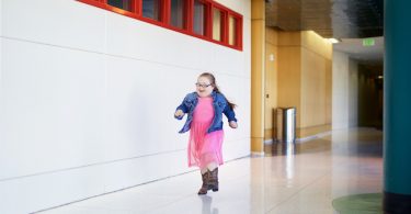 Milla runs down a hallway