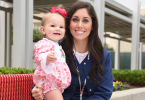 Little girl smiling and standing by her mom