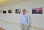 Man standing with photos on wall