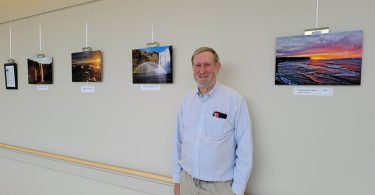 Man standing with photos on wall