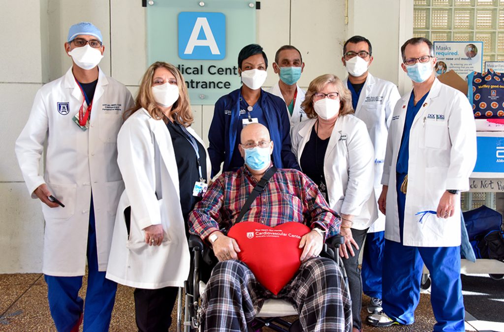 Man in wheelchair surrounded by doctors
