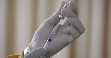 Hand filling a syringe