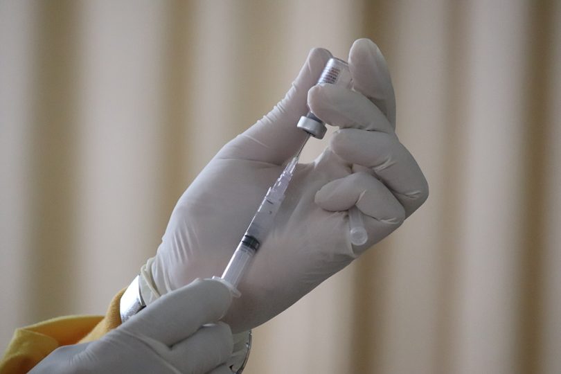 Hand filling a syringe