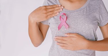Woman with breast cancer ribbon on her chest
