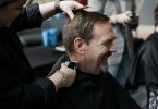 Man laughing while getting a haircut