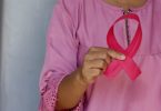 Hand holding pink ribbon