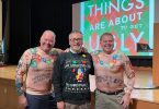 Three men posing in ugly Christmas sweaters