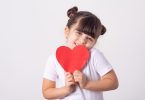 Little girl holding a paper heart