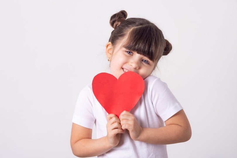 Little girl holding a paper heart
