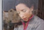 Woman crying behind rainy window