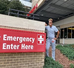 Woman posing for photo by ER sign