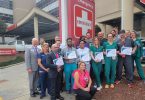 Group of people posing in front of ER sign