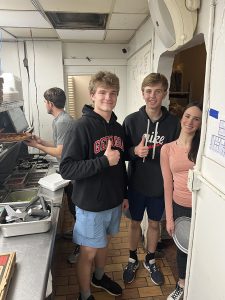 Three people posing in a restaurant kitchen