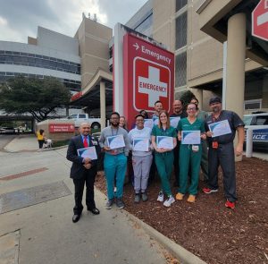 Group of people holding certificates in front of ER