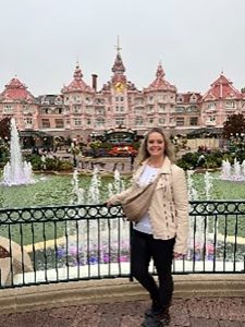 Woman standing in front of mansion