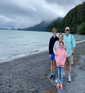 Family of four standing on a beach 