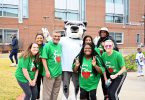 People standing with a mascot dressed as a jaguar