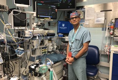 Dr. Ankit Jain standing next to operating room equipment