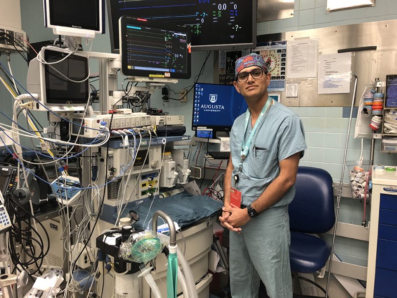 Dr. Ankit Jain standing next to operating room equipment