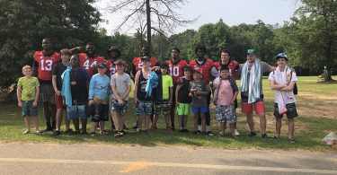 Football players with boy campers