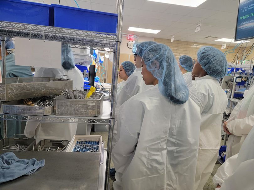 Students in bunny suits in operating room supply room