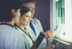 Three doctors looking at X-rays