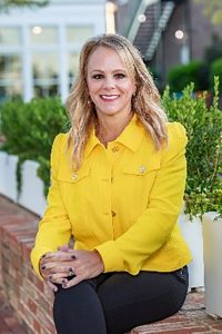 Woman in yellow shirt smiling for camera