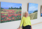 Woman smiling in front of paintings