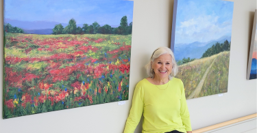 Woman smiling in front of paintings