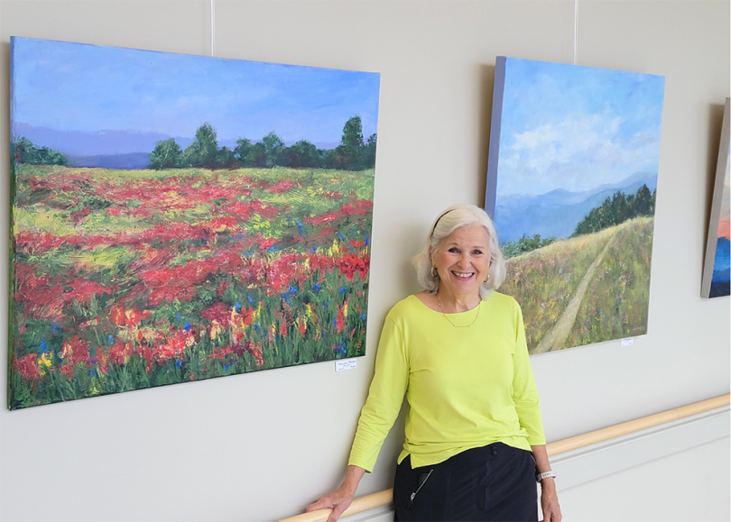 Woman smiling in front of paintings
