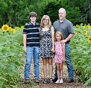 Family in field of sunflowers