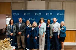 Honorees pose while serving food at the Wellstar MCG Health all-star breakfast