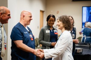 Man and woman speak to each other at the Wellstar MCG Health all-star breakfast