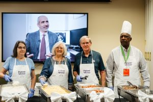 Patient and family providers pose while serving food at the Wellstar MCG Health all-star breakfast