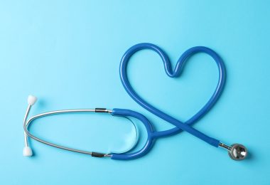 Stethoscope in shape of heart on blue background