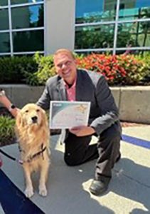 Man with certificate and dog