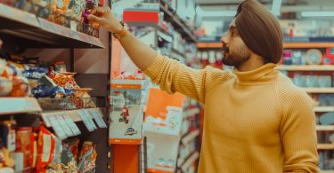 Male looking at different snack options on store shelf