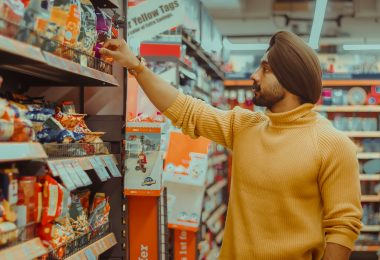 Male looking at different snack options on store shelf