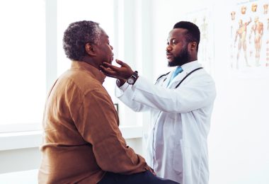 Doctor checking patient's neck