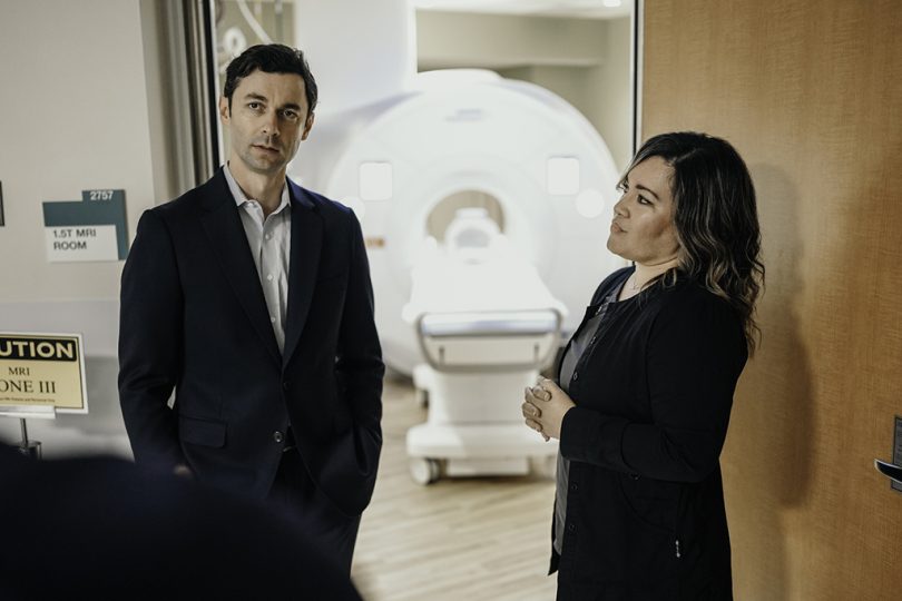 Man and woman talking in front of MRI machine