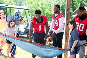 Football player swings hammock with kid inside