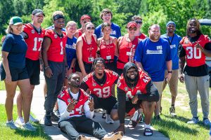 Group of people in red and blue shirts pose for group photo