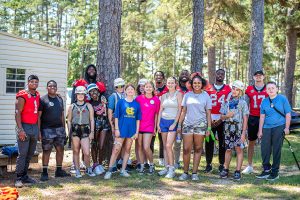 Group of teenagers pose for photo outside with football players