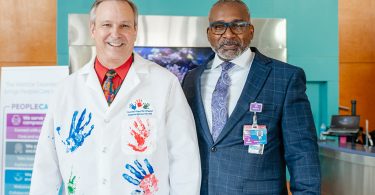 Doctor in white lab coat with handprints and man in suit