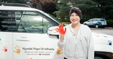 Teen patient holds up paint covered hand
