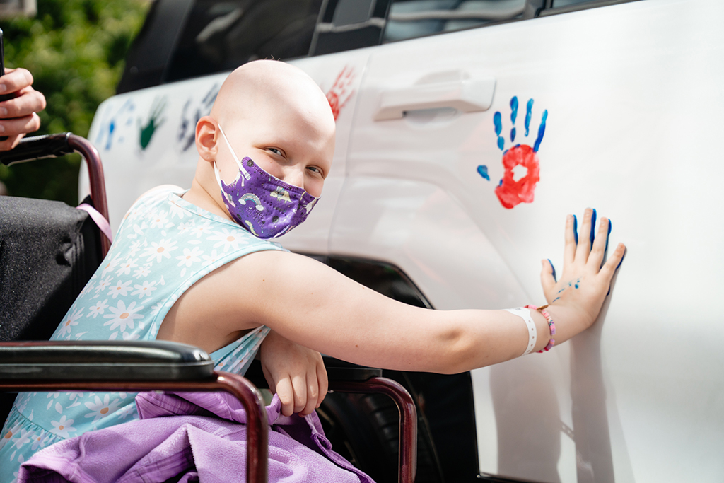 A patient puts her handprint on a white car